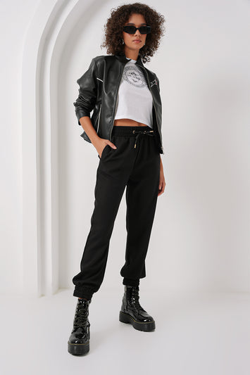 Woman wearing black cargo pants with graphic tee and leather jacket