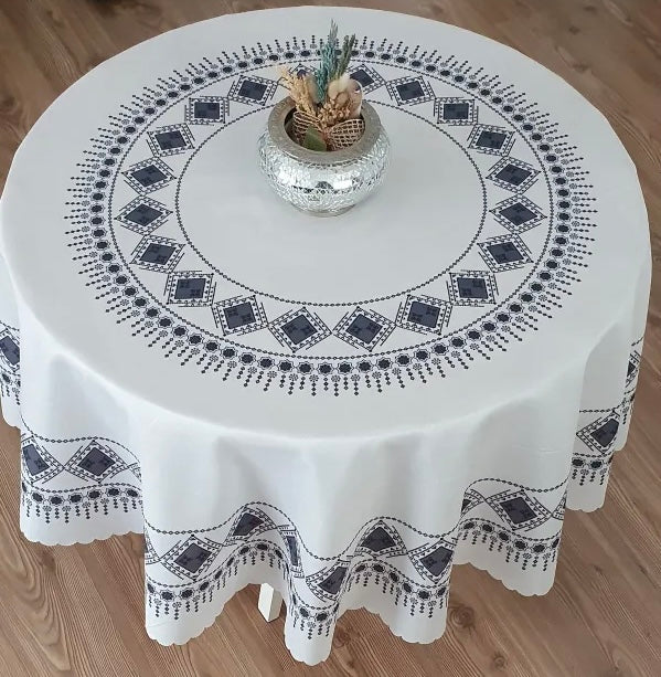 <tc>Nappe ronde en polyester imprimée avec motif de broderie.</tc>