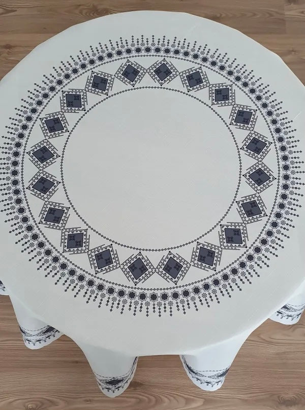 <tc>Nappe ronde en polyester imprimée avec motif de broderie.</tc>